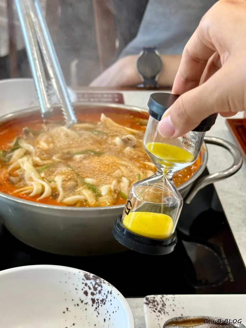 Pot combining noodles, brisket, and live abalone