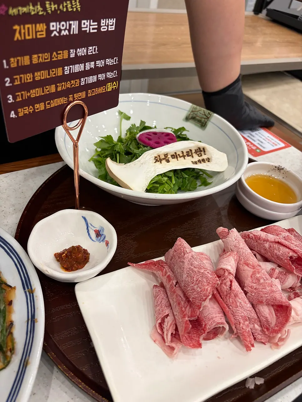 차돌미나리쌈을 참기름장에 찍는 모습