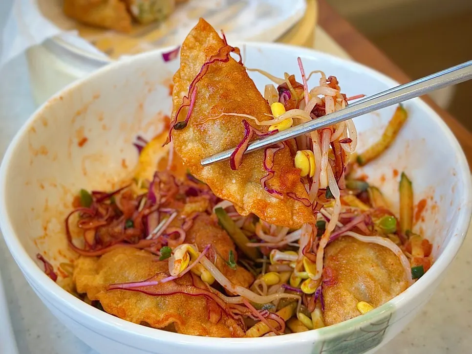 Fresh vegetables and dumplings mixed in spicy-sour sauce