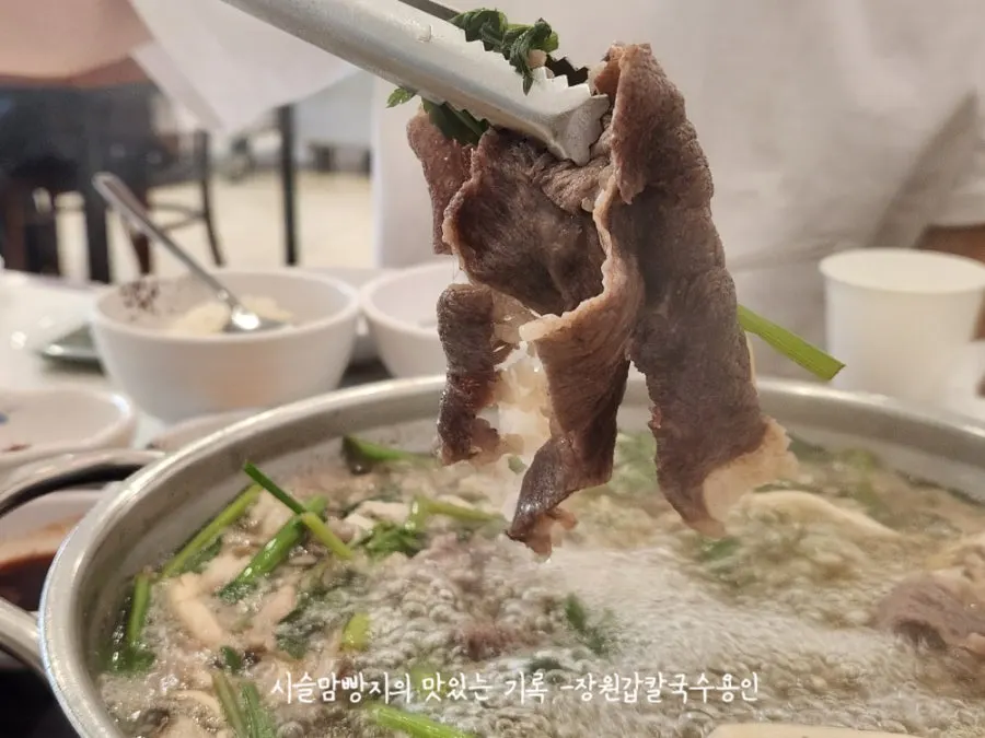 Brisket and minari wrap dipped in sesame oil sauce