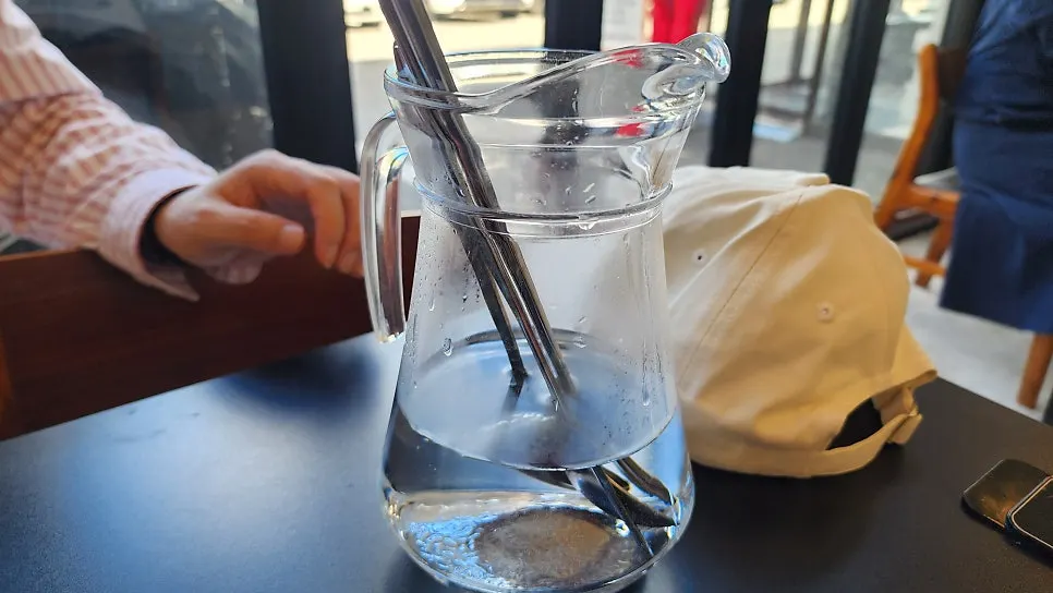Spoons and chopsticks served sitting in hot water