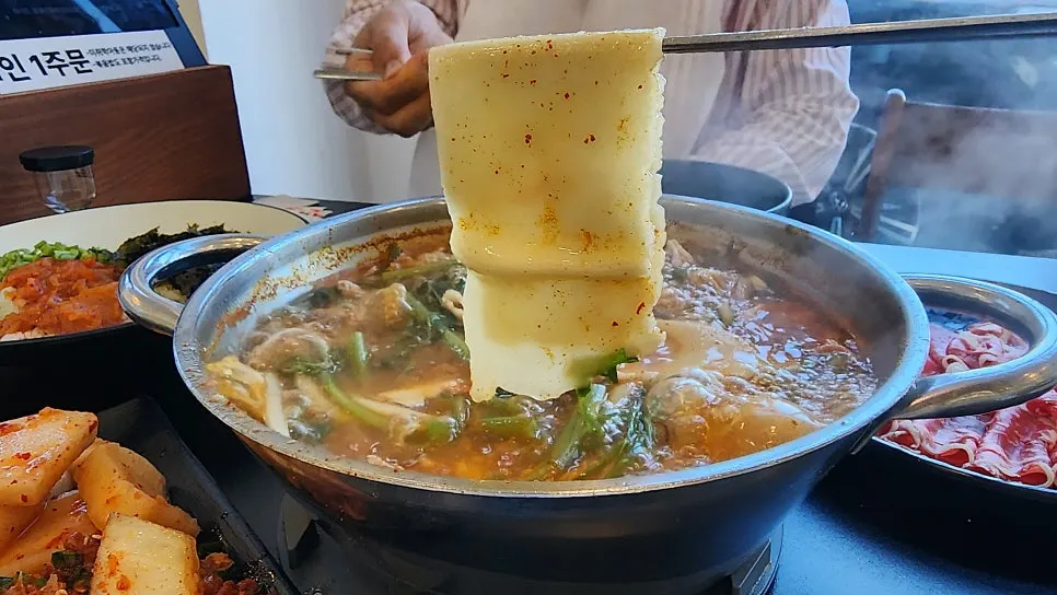 Wrapping meat and vegetables in flat kalguksu noodles
