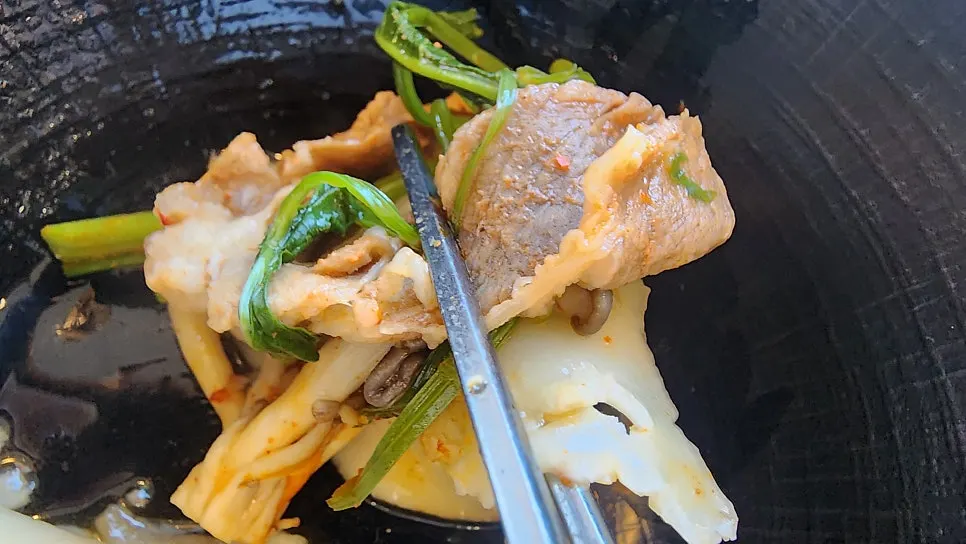 A plate of cooked beef and vegetables pulled from the broth