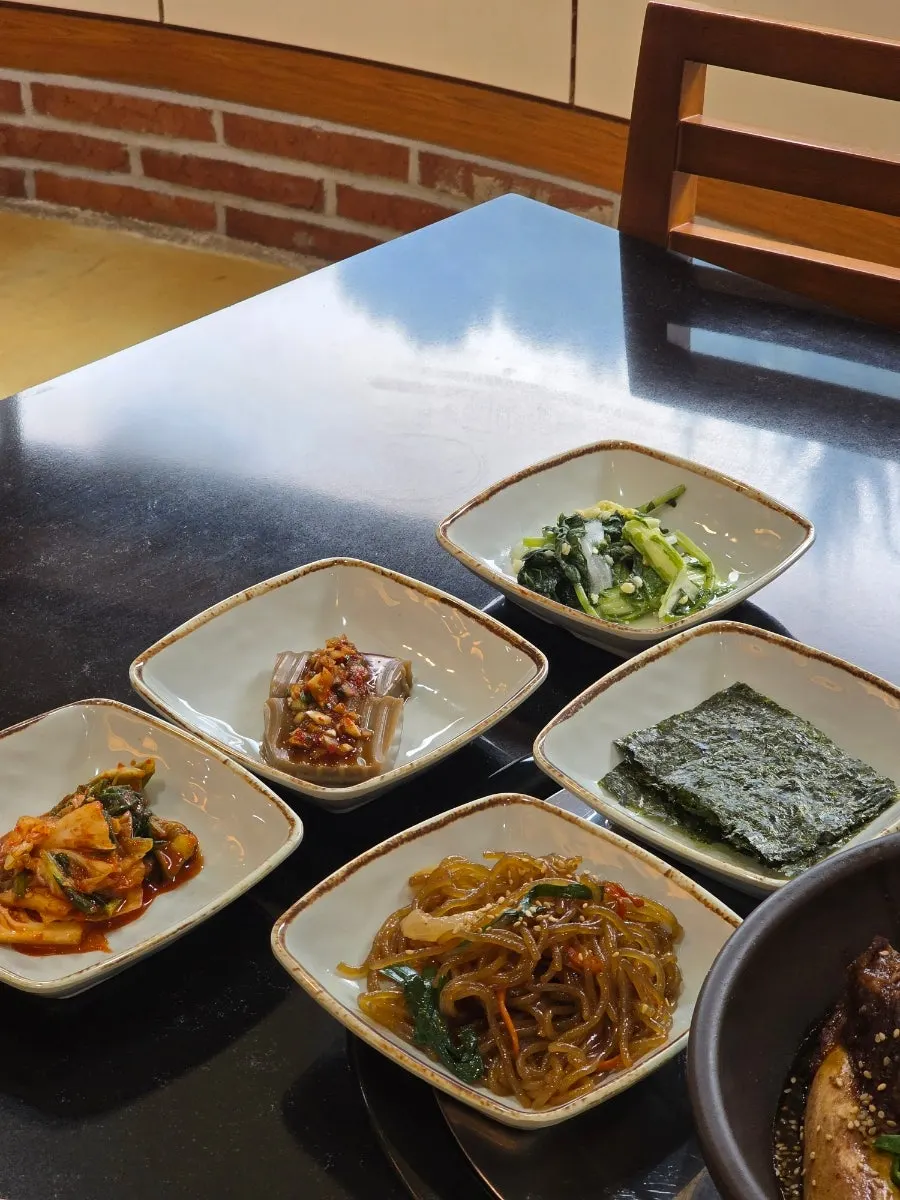 Napa cabbage kimchi, acorn jelly, barley-yeolmu kimchi, and japchae banchan