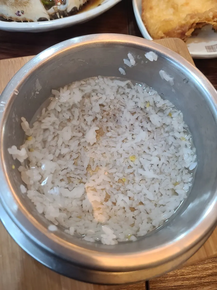 A spoonful of sotbap eaten with soy-marinated crab
