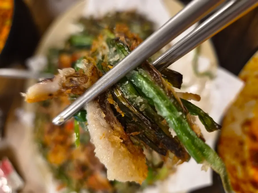Cross-section of the jjukkumi seafood chive pancake packed with chives