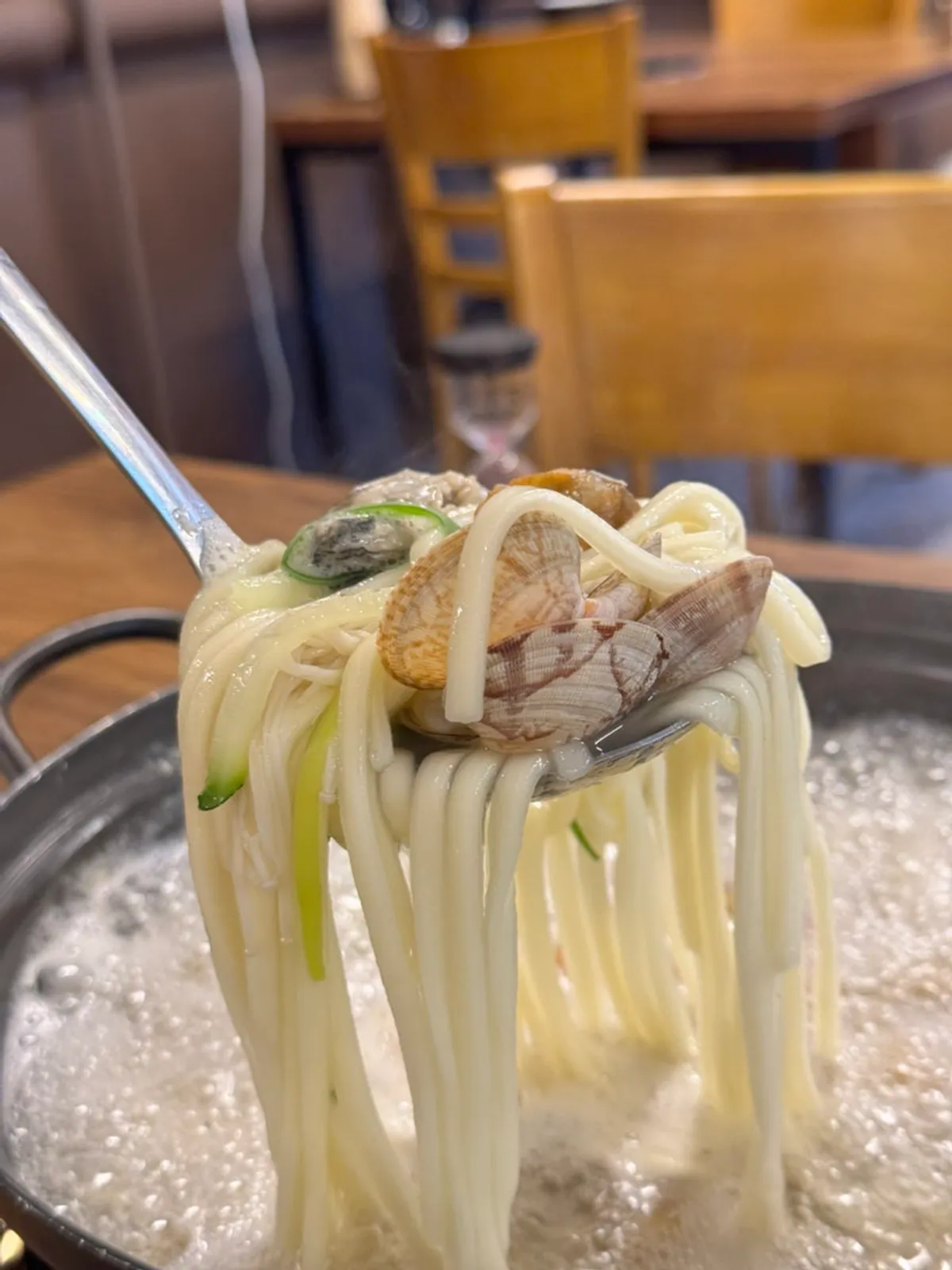 A piece of jjukkumi seafood chive pancake dipped in soy sauce
