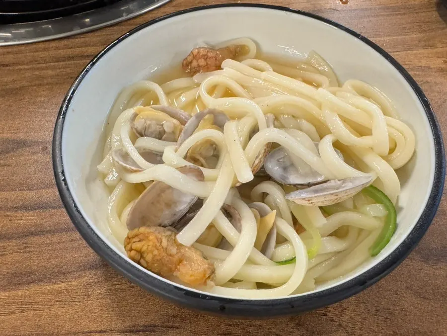 A finished bowl of pufferfish seafood kalguksu, fully cooked