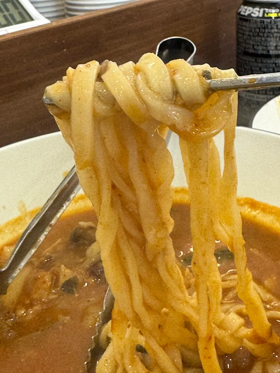 Chewy kalguksu noodles lifted out of the pot