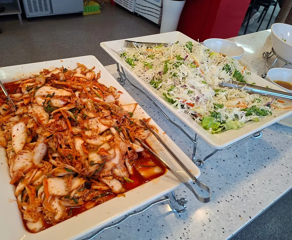 집밥 반찬이 줄지어 놓인 배식대