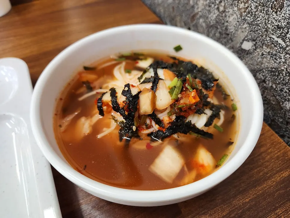 Janchi-guksu topping station with seaweed flakes and sauce