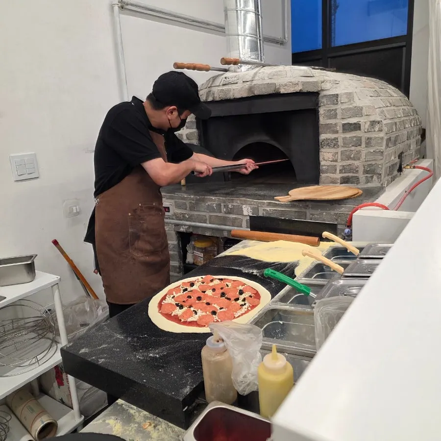 Pizza being put into the oven to bake