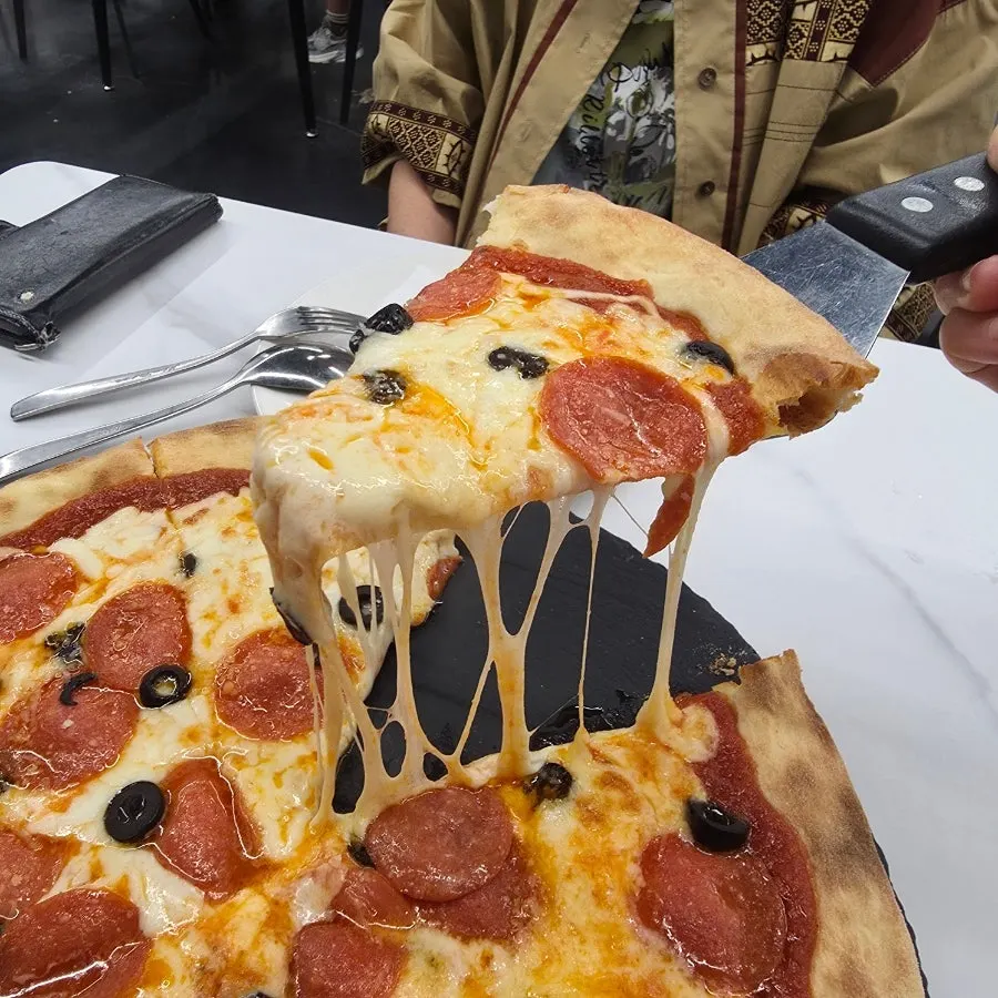 A slice of pizza with cheese stretching long