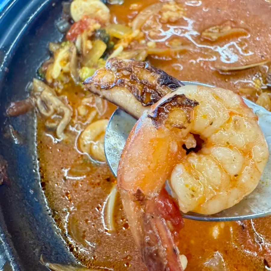 Spicy broth with scorched rice and seafood