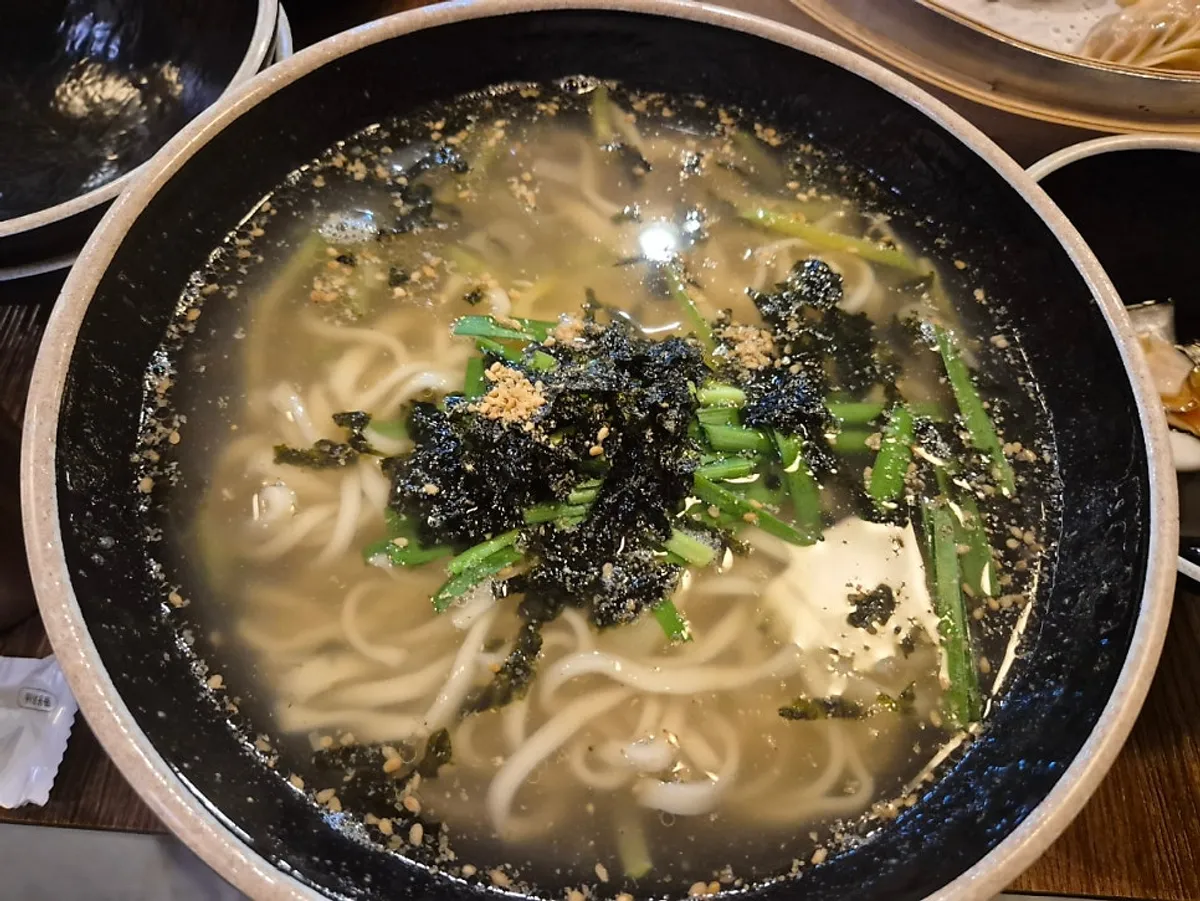 칼국수와 비빔칼국수, 김치가 놓인 테이블