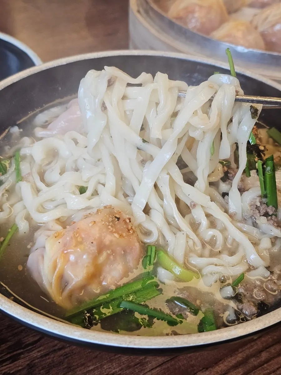 House-made kalguksu noodles lifted with chopsticks