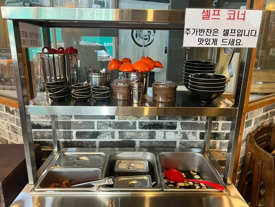 Self-serve side dish corner with kimchi and soy sauce