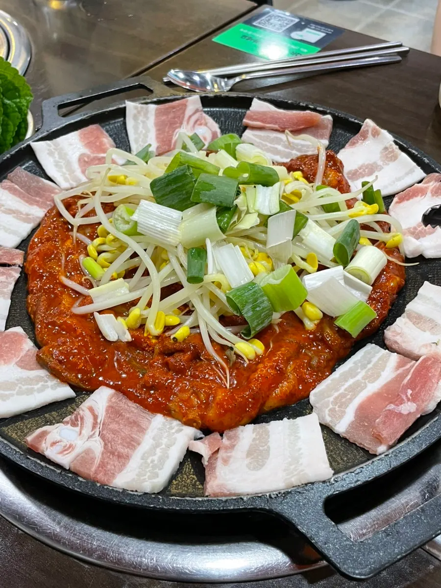 삼겹살이 테두리를 둘러싼 철판 쭈꾸미