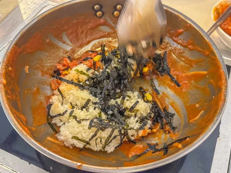 Rice set up for fried rice with seaweed flakes, kimchi, and corn