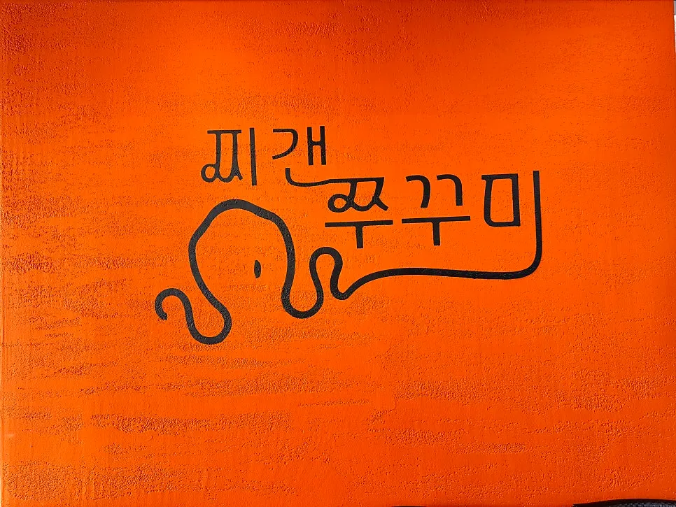 주황색 벽과 쭈꾸미 캐릭터 로고