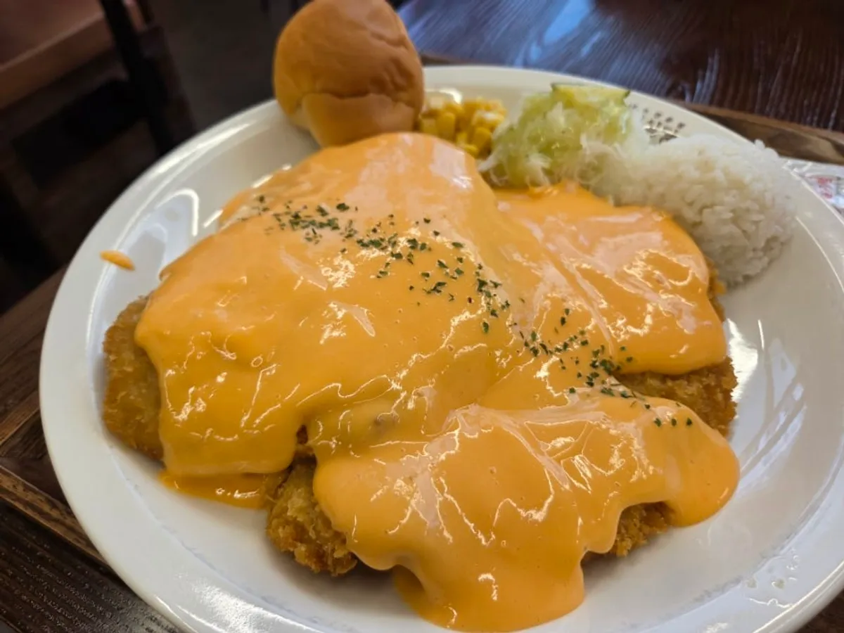 Close-up of the pork cutlet piled high with cheddar cheese