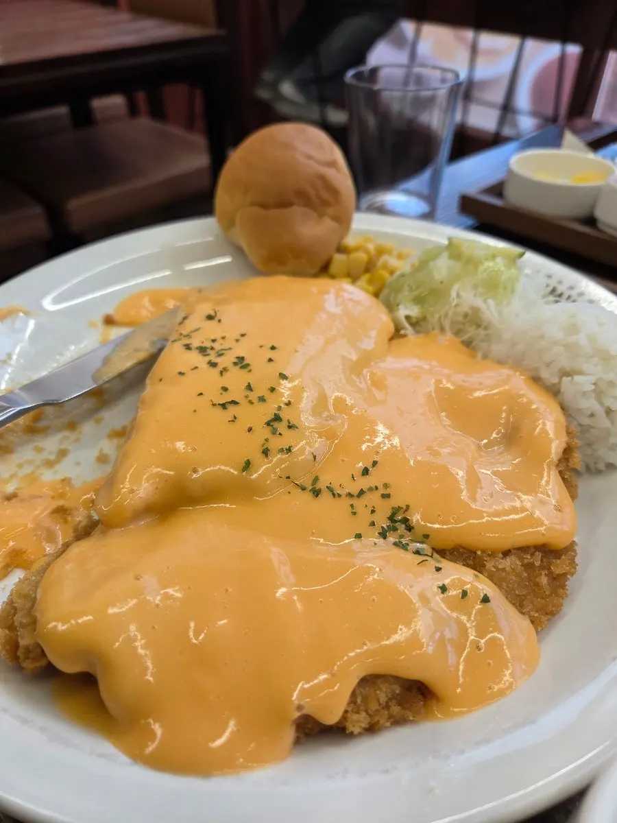 A piece of pork cutlet with stretchy melted cheese