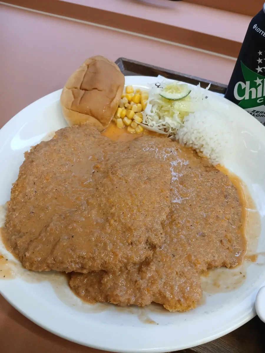 Two palm-sized cutlets with morning bread, salad, and corn