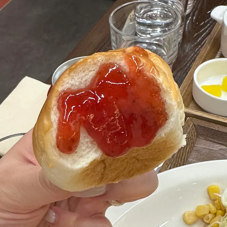 Close-up of strawberry jam paired with dinner rolls