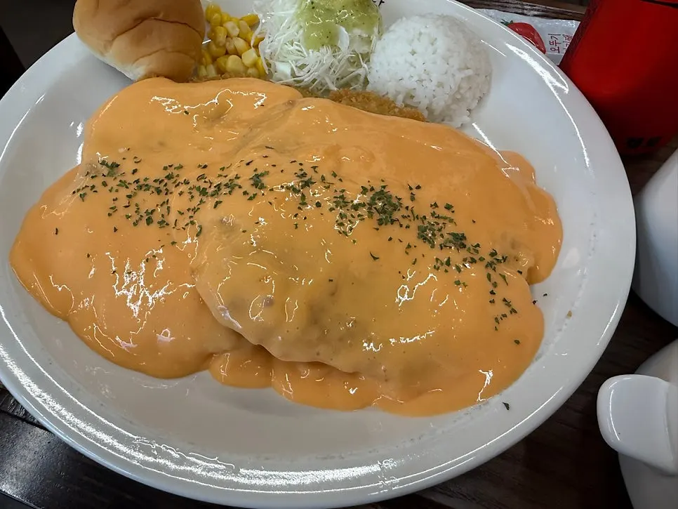 Pork cutlet generously covered in cheddar cheese sauce