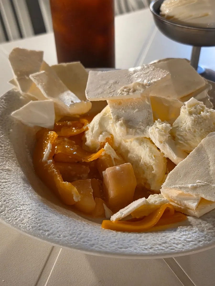 Exterior of the crack-open summer peach pavlova