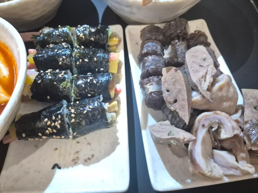 Fritters and mini gimbap dipped in tteokbokki sauce