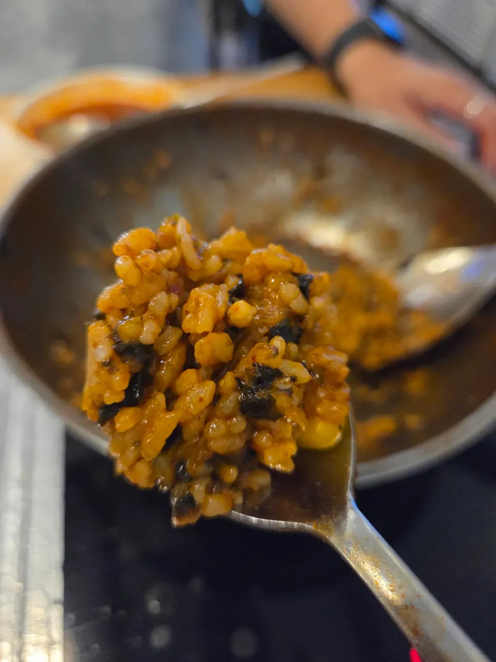 A spoonful of fried rice cooked in thick sauce