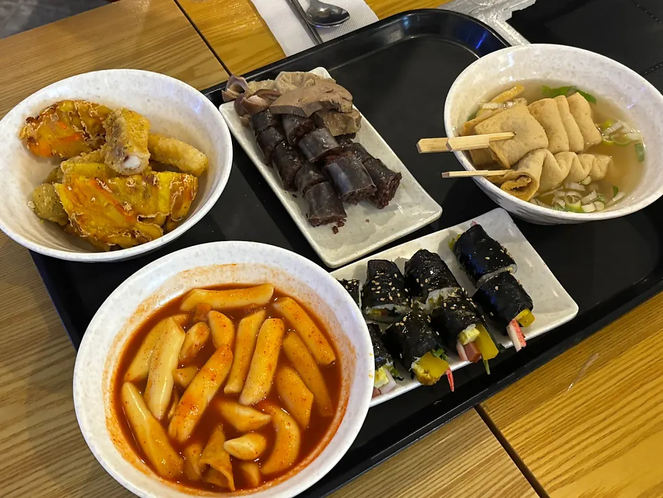 Table with tteokbokki and fried snacks together