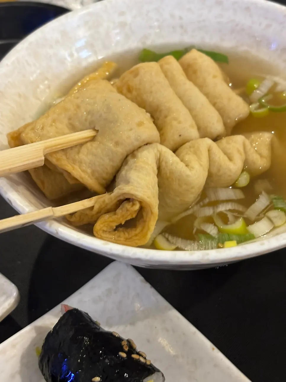 Three curly fish cake skewers with broth