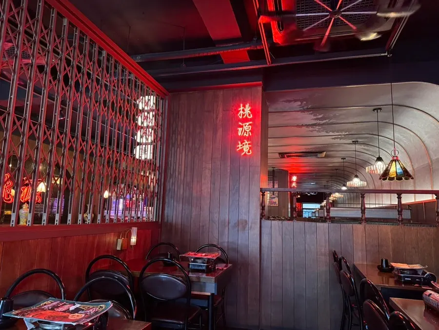 Red neon 'Peach Blossom Land' lettering on the wall