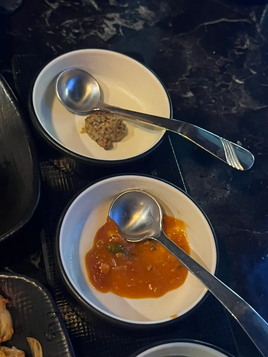 Plates of pink salt, whole grain mustard, and other sauces