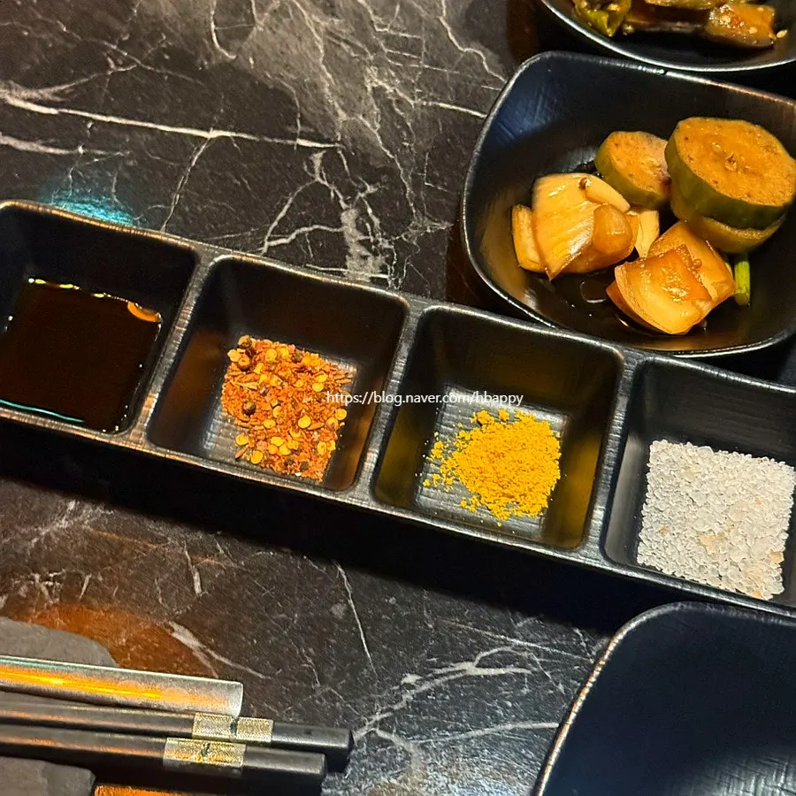 Plate of accompanying side dishes with garlic sauce and pickles