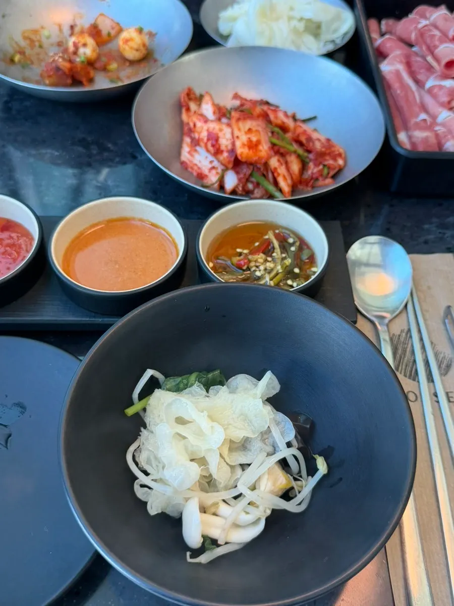 A wrap of cooked chuck roll with bean sprouts and minari