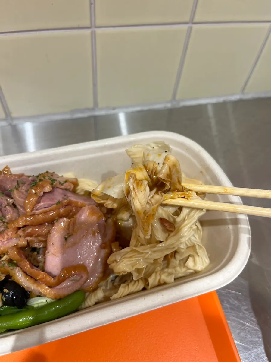 Close-up of mala tofu noodles mixed with olives and green beans