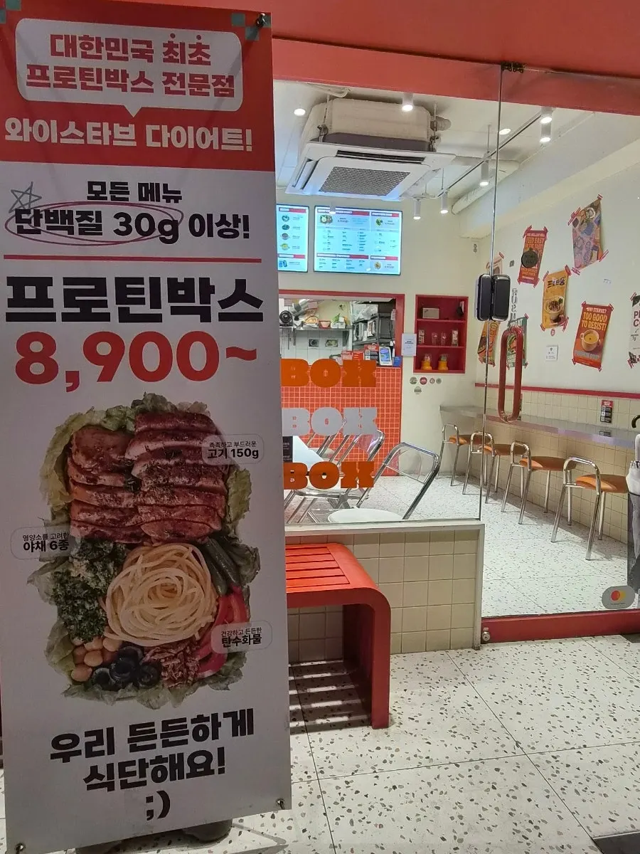 입구 옆 메뉴 배너와 무인 키오스크