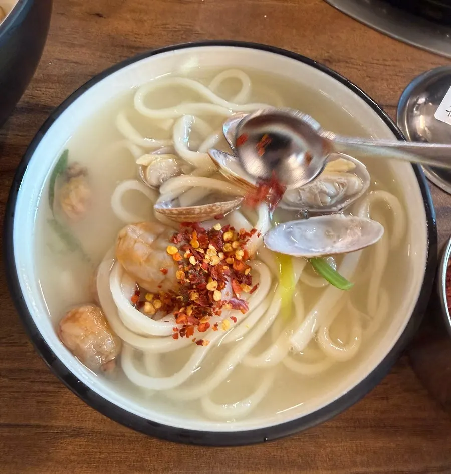 House-made kalguksu noodles lifted out of the pot