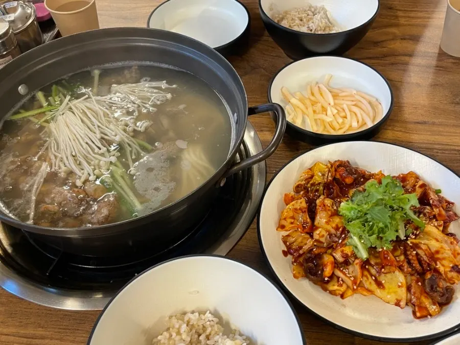 Bokhaemul kalguksu set spread with noodles, jjukkumi, and barley rice
