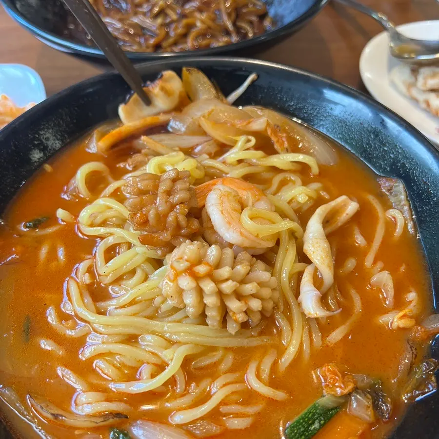 Broth and noodles of the signature steamed bone-broth seafood jjampong