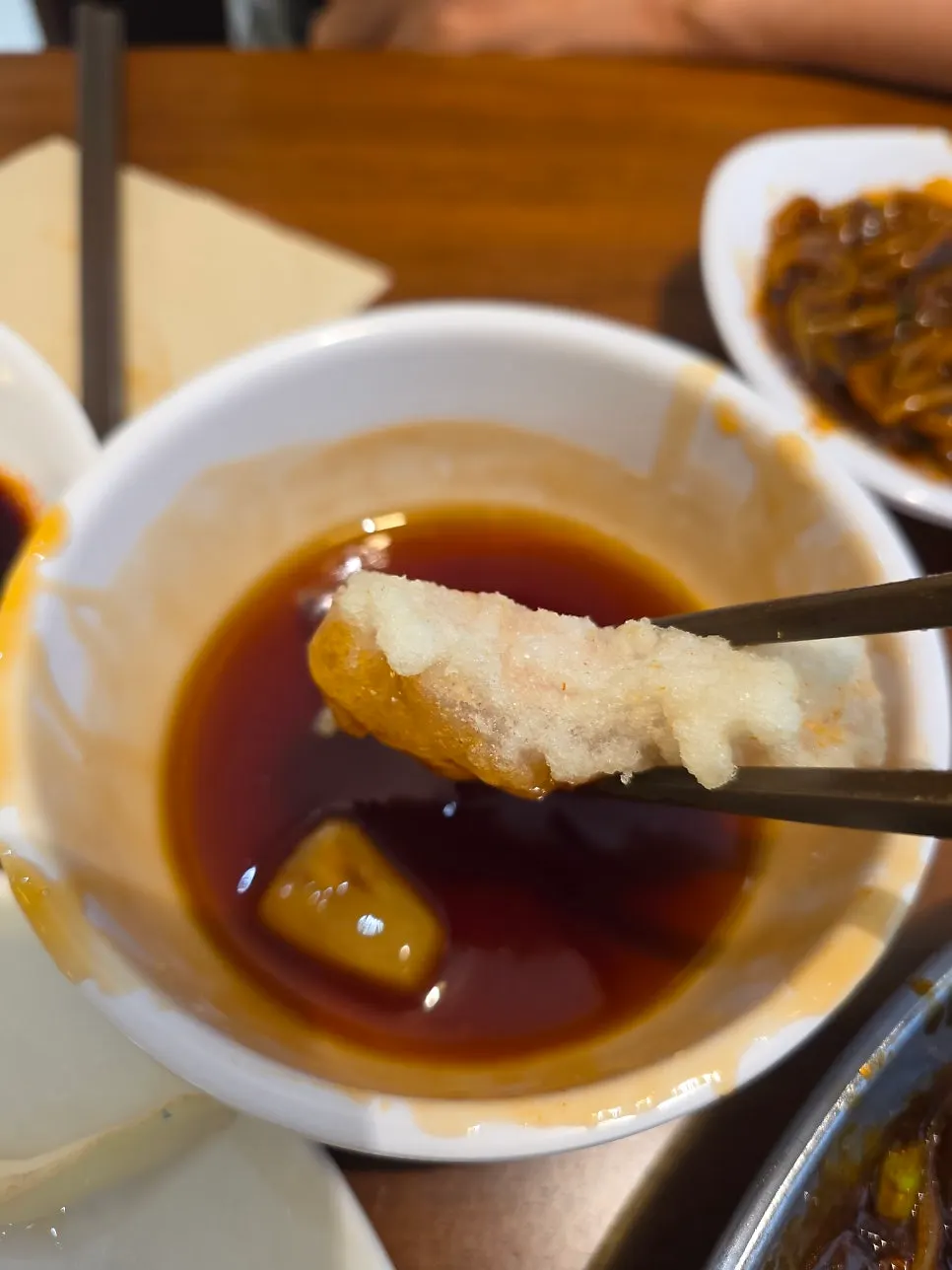A piece of tangsuyuk dipped in the house sauce