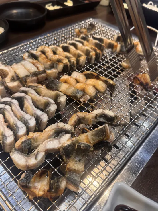 Self-grilled freshwater eel cooking on charcoal
