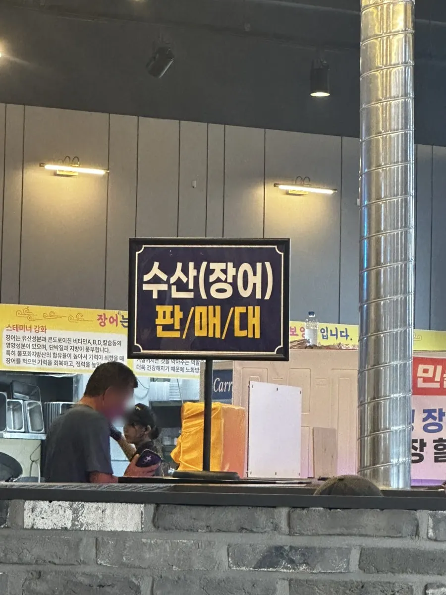 Sign guiding customers to pick eel at the seafood display case