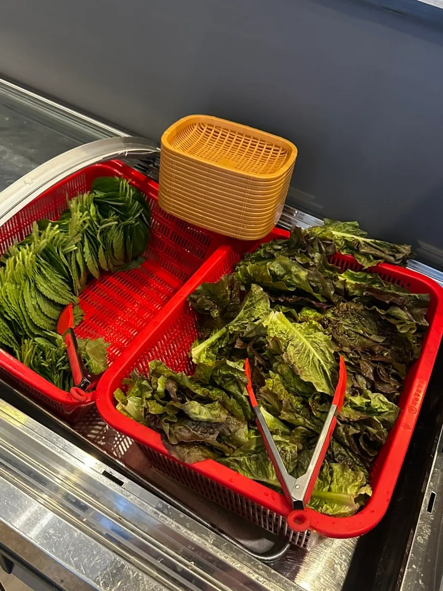 Self-serve bar with wrapping greens, pickles, and sauces