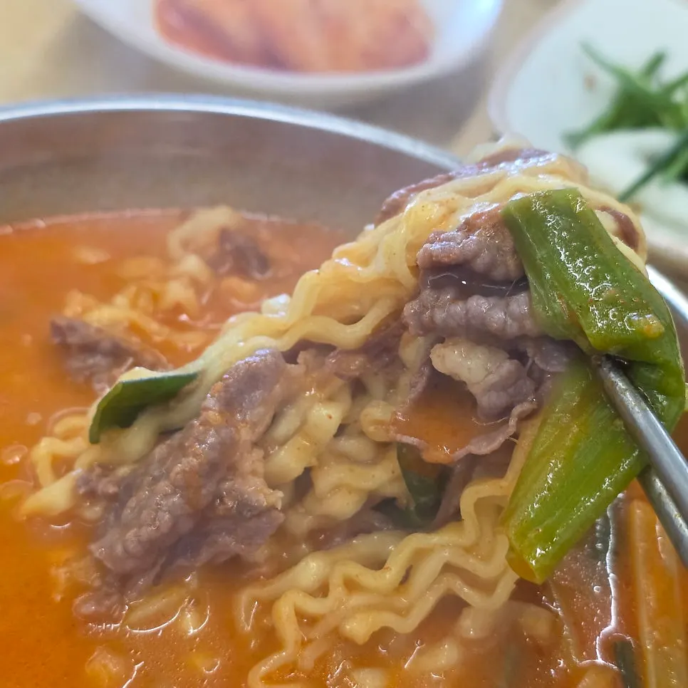 붉은 육수에 배인 차돌육칼국수 면발