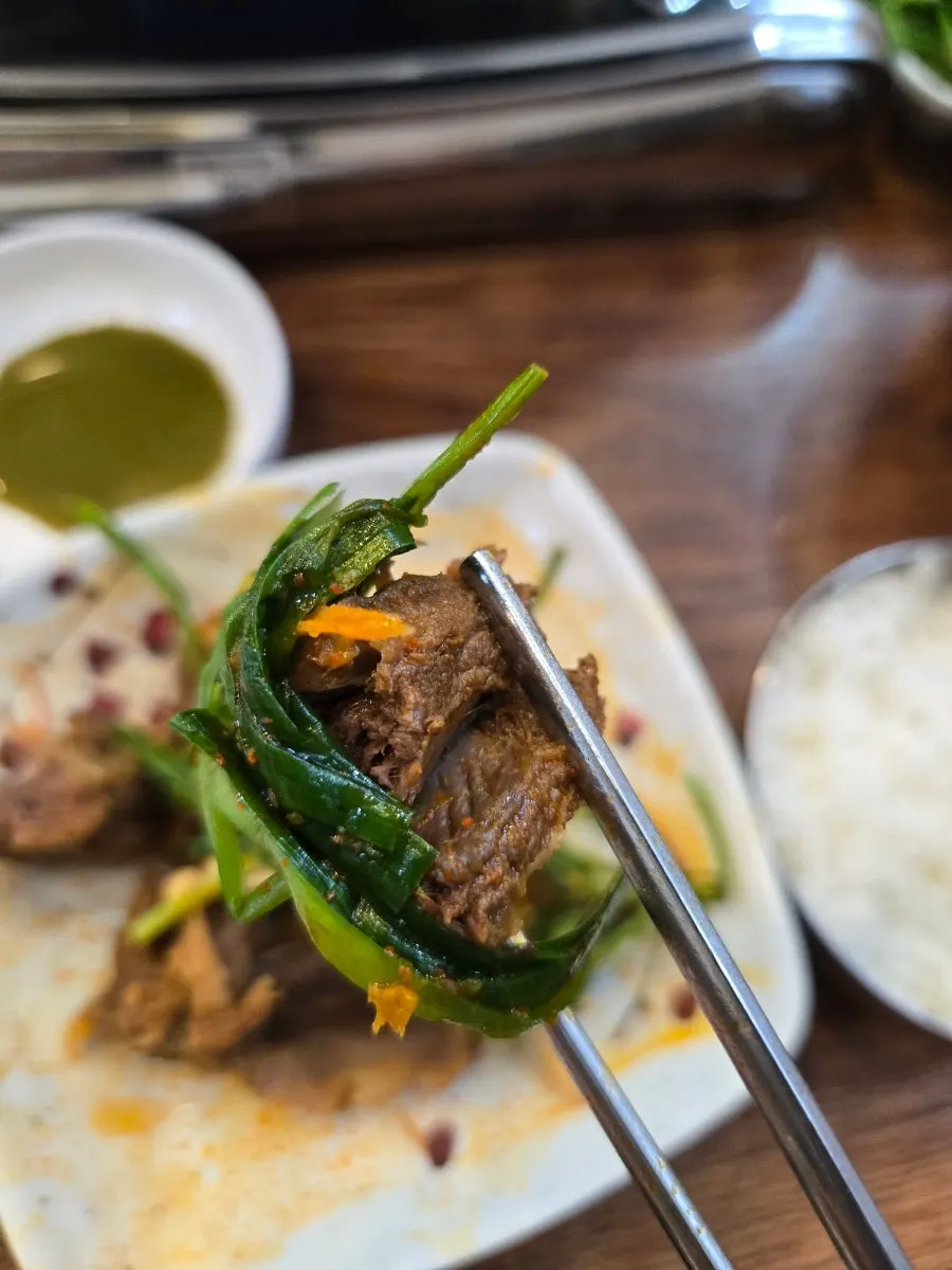 Short rib meat dipped in wasabi soy sauce with chives