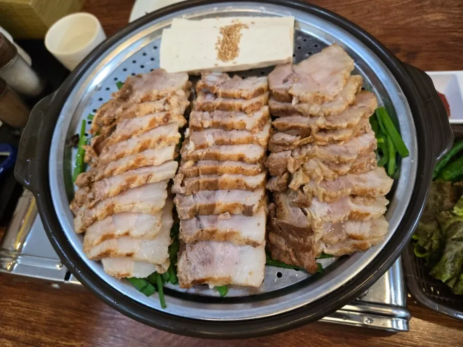 Steamed pork on chives served on a grill plate